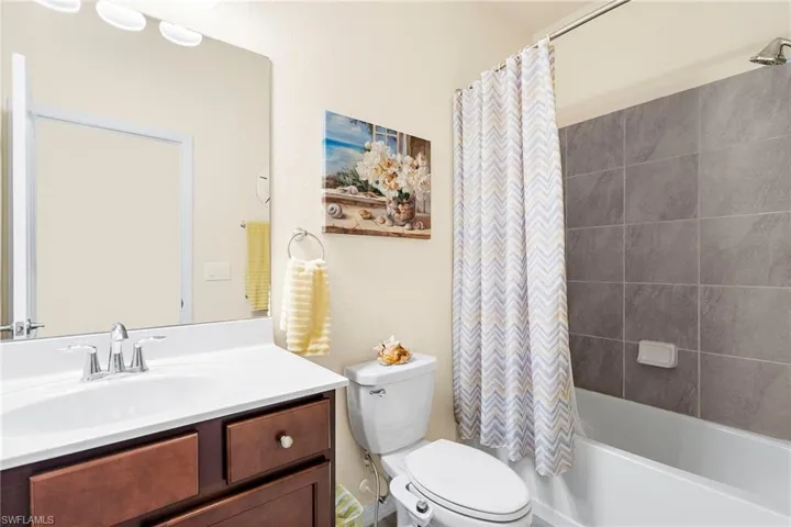 Full bathroom with toilet, vanity, and shower / tub combo with curtain