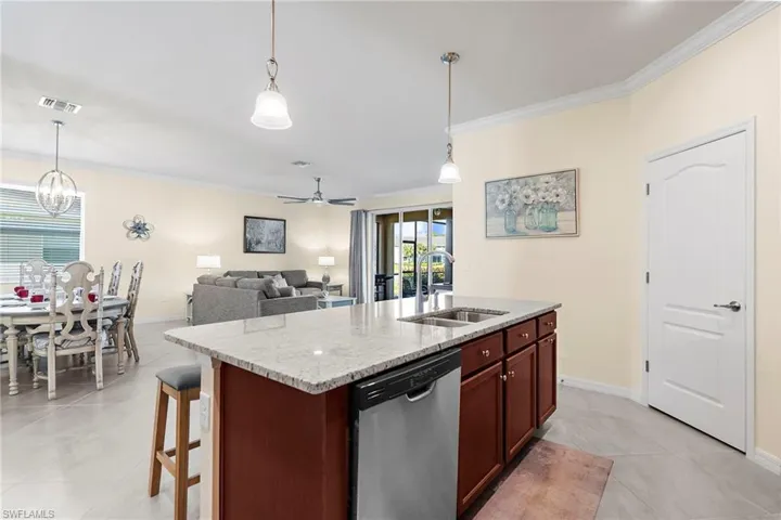 Kitchen with dishwasher, ceiling fan with notable chandelier, decorative light fixtures, and sink