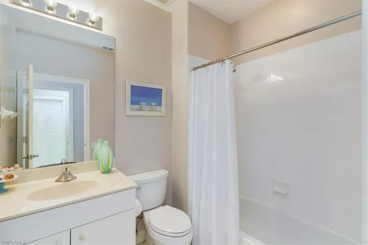Full bathroom with toilet, shower / bath combo, and large vanity