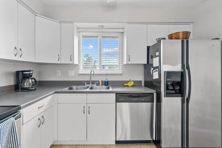 Kitchen featuring white cabinetry, sink, and stainless steel appliances