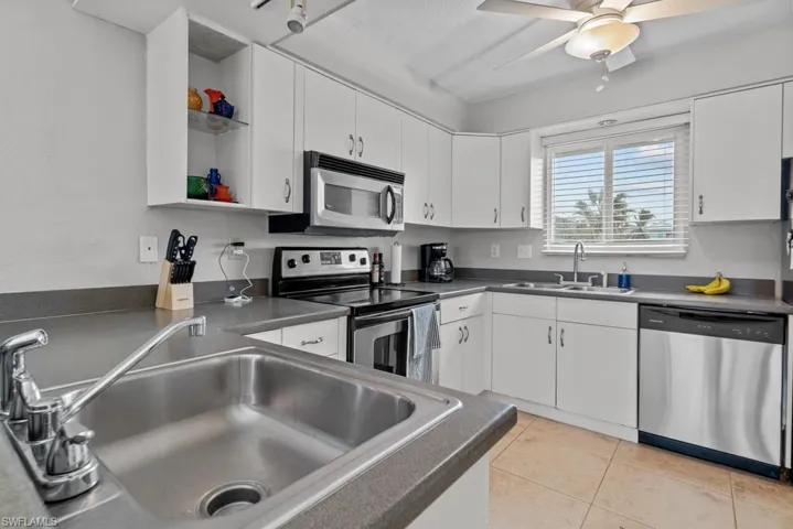 Kitchen with sink, white cabinets, and appliances with stainless steel finishes