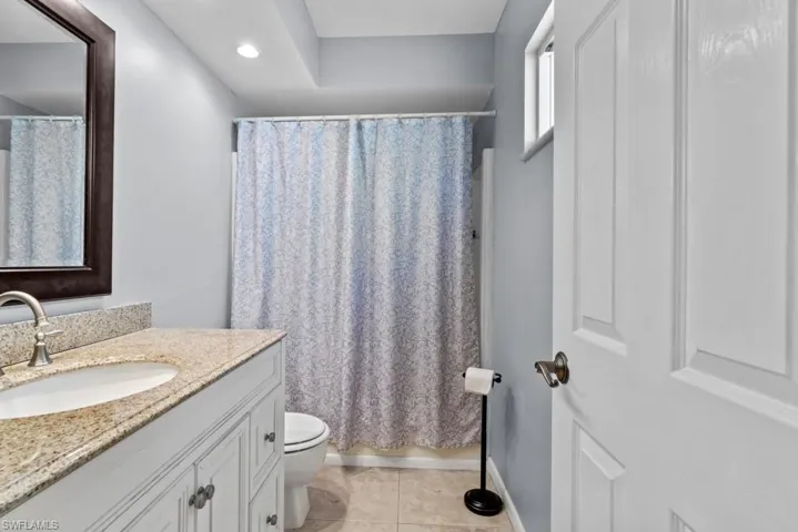 Full bathroom featuring tile patterned flooring, vanity, shower / bathtub combination with curtain, and toilet