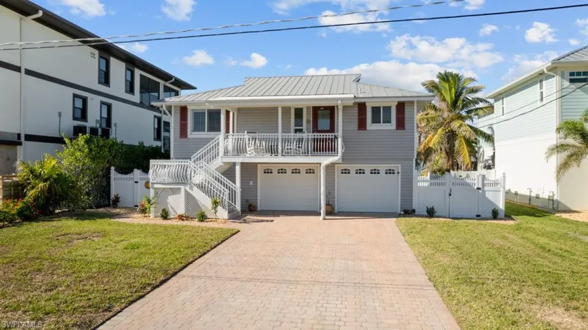 View of front of property featuring a porch, a garage, and a front yard