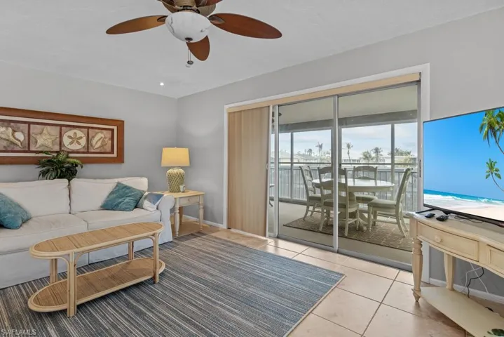 Living room featuring light tile patterned floors and ceiling fan