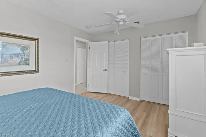 Bedroom with multiple closets, ceiling fan, and light hardwood / wood-style flooring