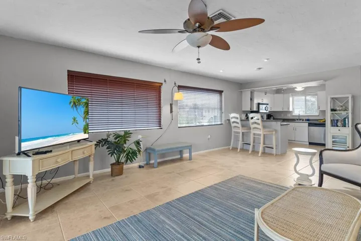Tiled living room with ceiling fan and sink