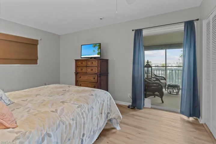 Bedroom with access to outside, light wood-type flooring, and a closet