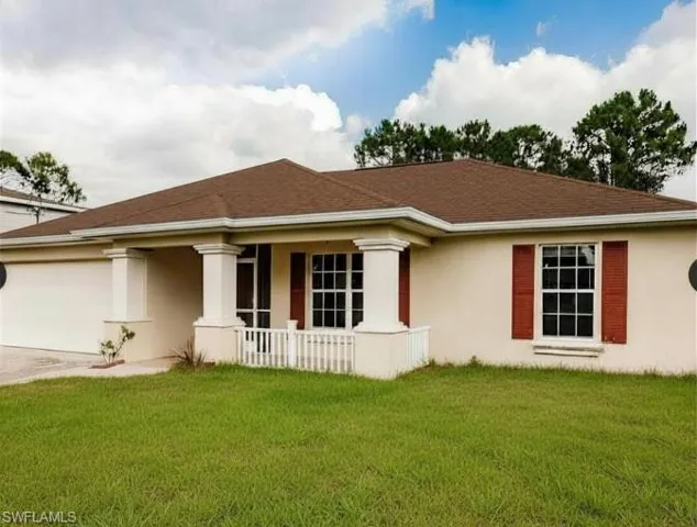 Single-story stucco exterior featuring a covered front entry with white columns and railing