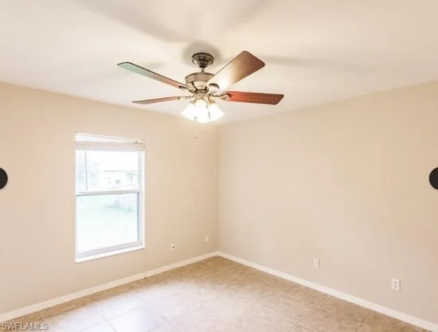 Neutral-toned room featuring a single window, a ceiling fan with integrated lighting, and tile flooring
