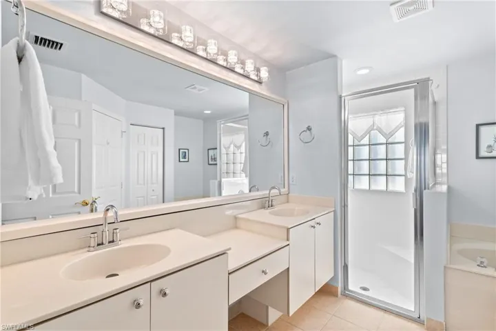 Bathroom featuring vanity, tile patterned floors, and separate shower and tub