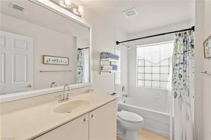 Full bathroom featuring toilet, vanity, tile patterned flooring, and shower / bathtub combination with curtain