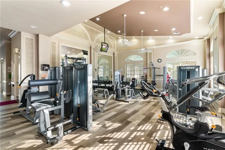 Workout area with a high ceiling, ornamental molding, and hardwood / wood-style flooring