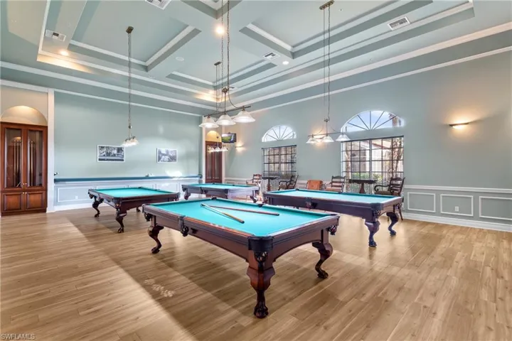 Game room with pool table, a towering ceiling, light wood-type flooring, beam ceiling, and coffered ceiling