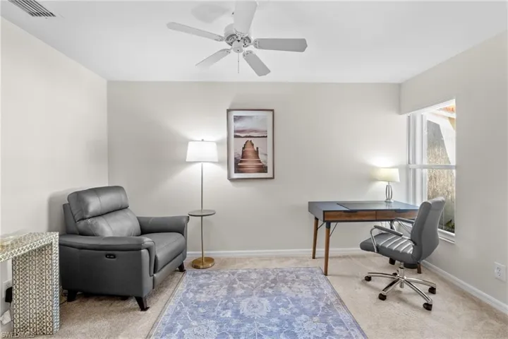 Office area with light colored carpet and ceiling fan
