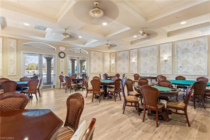 Dining space featuring french doors, light wood-type flooring, crown molding, ceiling fan, and coffered ceiling