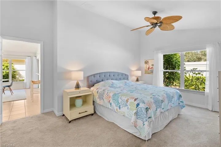 Carpeted bedroom with lofted ceiling and ceiling fan