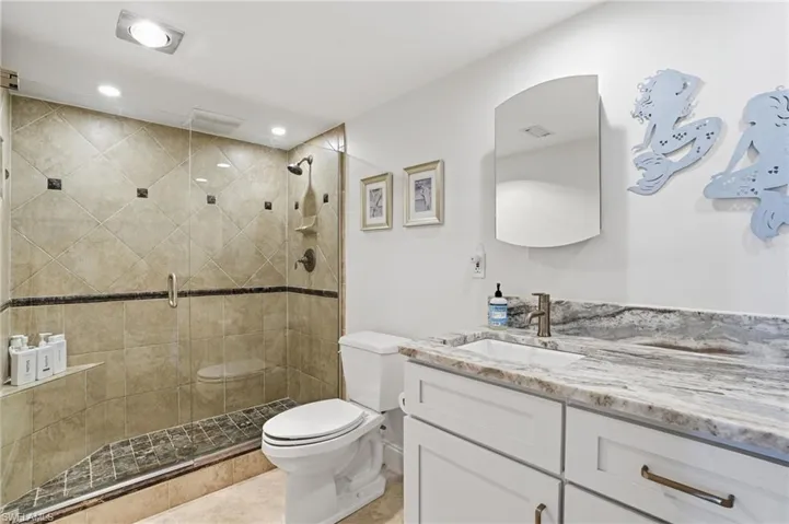 Bathroom featuring vanity, a stall shower, and recessed lighting - Virtually Edited Image