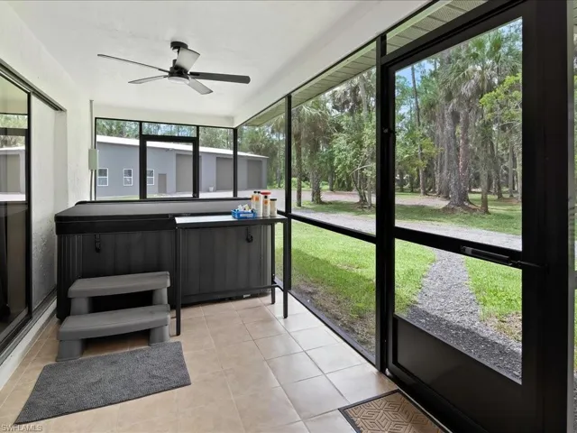 Sunroom / solarium featuring a hot tub and a ceiling fan