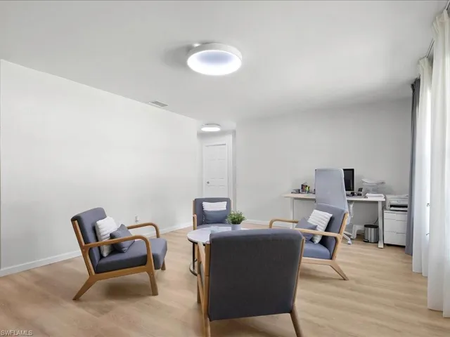 Sitting room with an office area and light wood-style floors