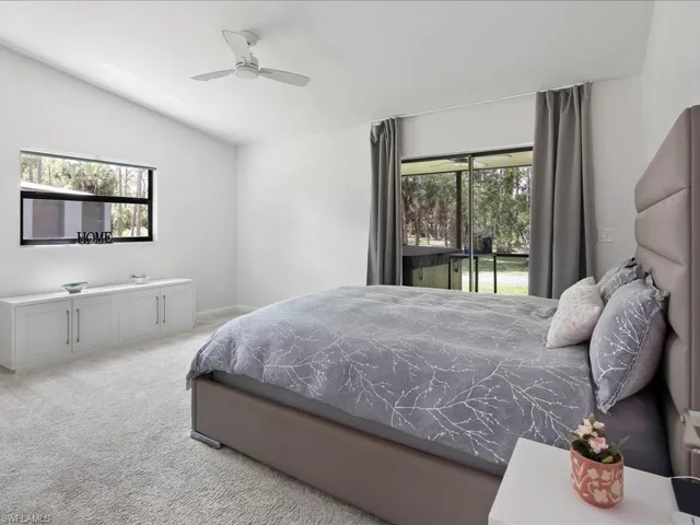 Bedroom with lofted ceiling, carpet, access to exterior, and a ceiling fan