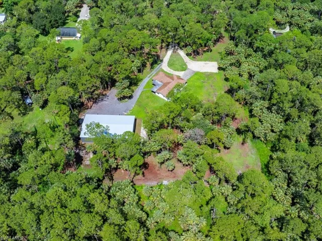 View of property location with a heavily wooded area