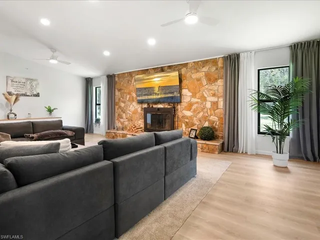 Living area with a ceiling fan, light wood-style floors, healthy amount of natural light, and recessed lighting