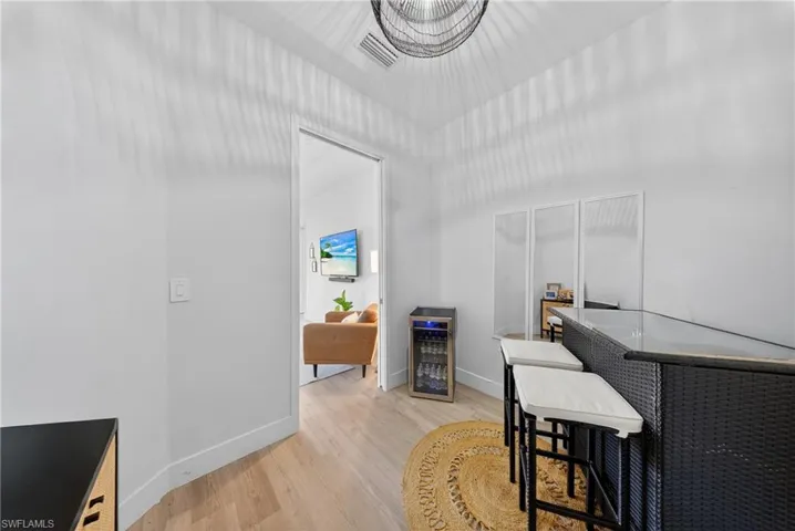 Office area with light wood-style flooring and beverage cooler