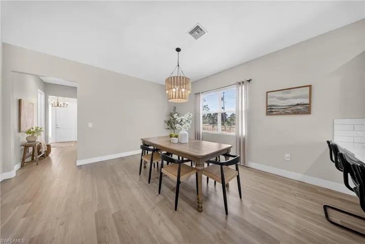 Dining room with suspended lighting and light wood-style floors