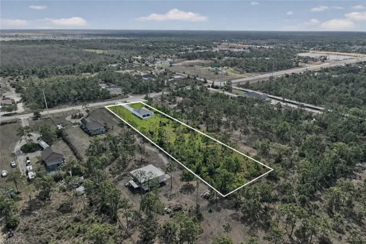 Aerial view of property's location featuring property boundaries highlighted and a heavily wooded area