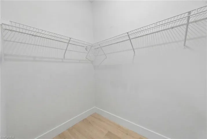 Walk in closet with light wood finished floors