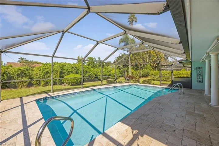 Outdoor pool featuring a sunroom, a patio area, and glass enclosure