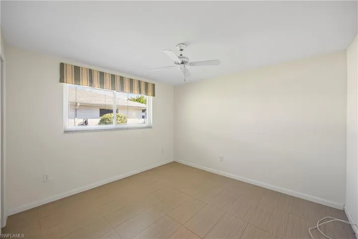 Empty room featuring baseboards and a ceiling fan