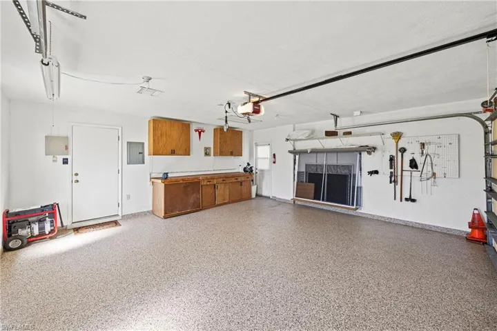 Garage featuring electric panel and a garage door opener