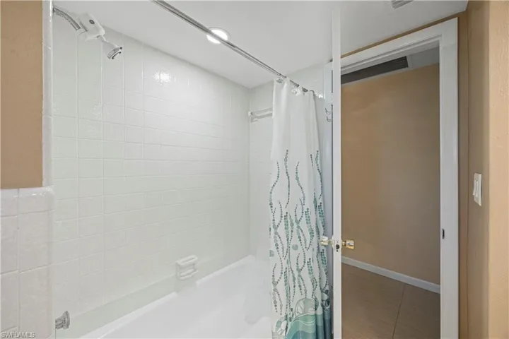 Bathroom with shower / tub combo and tile patterned floors