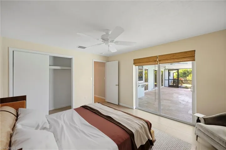 Guest bedroom featuring access to exterior, a ceiling fan, and a closet