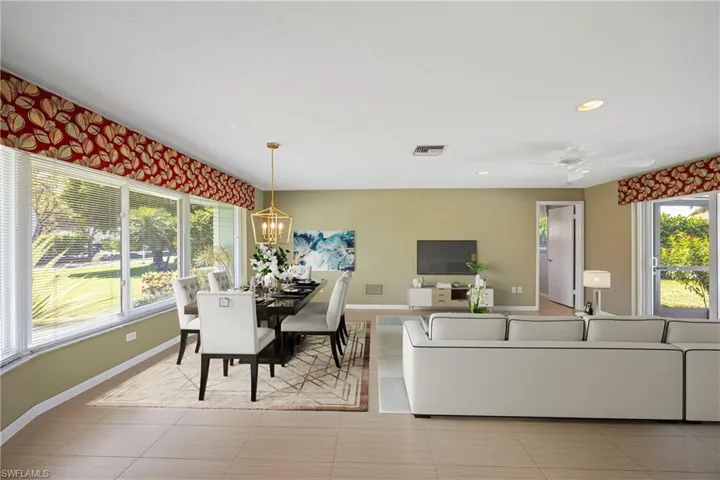 Dining space with adjoining Living Room recessed lighting, ceiling fan, and light tile patterned flooring