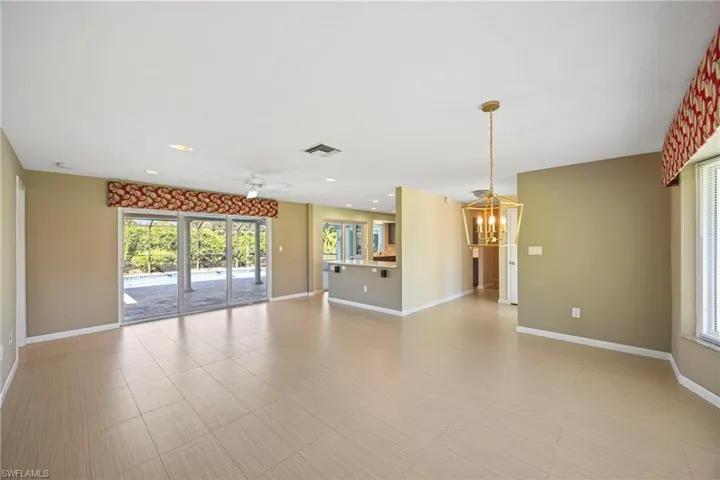 Unfurnished living room featuring recessed lighting, a ceiling fan, and a chandelier