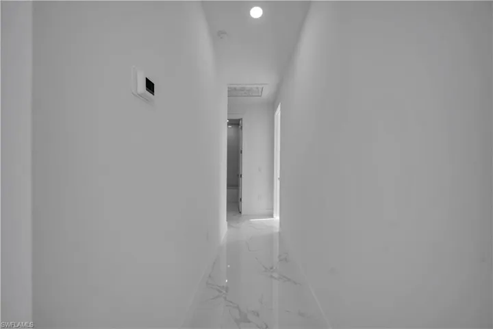 Corridor with recessed lighting and light marble finish flooring