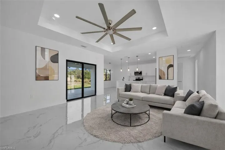 Living room with ceiling fan, light marble finish flooring, and recessed lighting