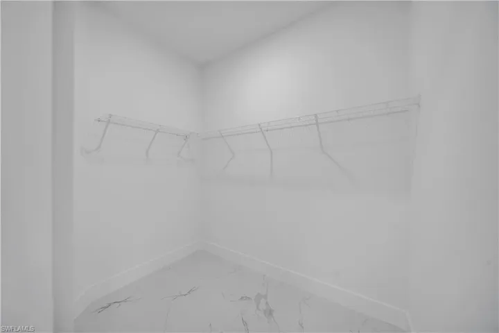 Walk in closet featuring light marble finish floors