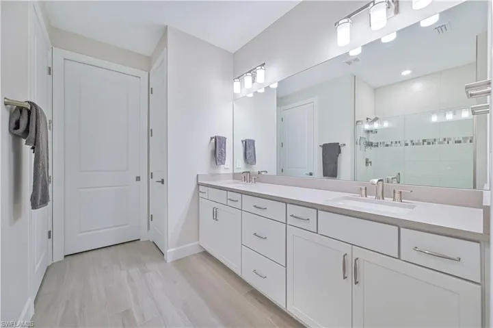 Bathroom featuring vanity, wood-type flooring, and walk in shower