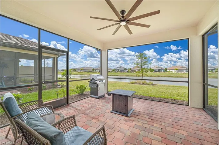 Sunroom / solarium featuring a water view and ceiling fan