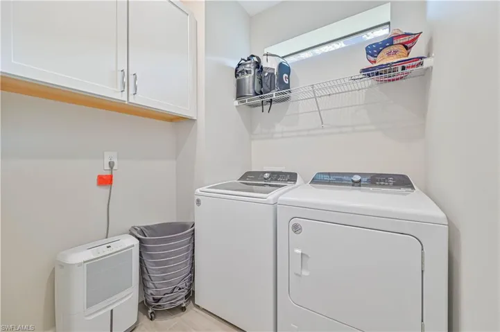 Laundry room with independent washer and dryer and cabinets