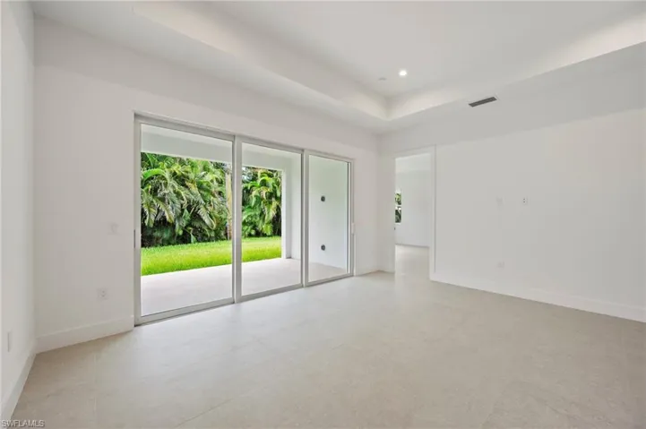 Empty room with a raised ceiling and recessed lighting