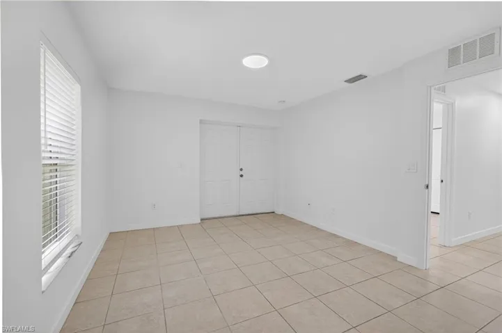 Empty room with light tile patterned floors and baseboards