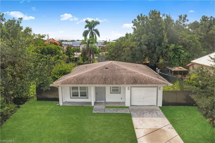 View of front of home featuring concrete driveway, an attached garage, and a shingled roof