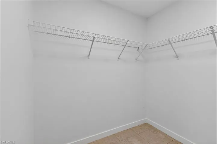 Walk in closet with light tile patterned floors