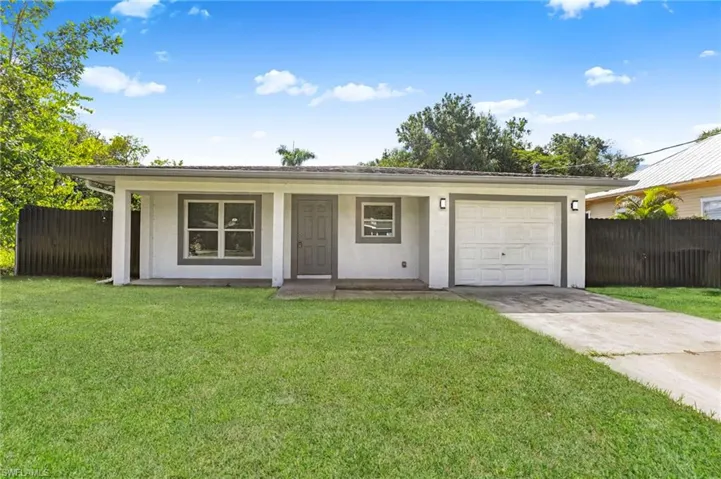 Ranch-style home featuring driveway, a garage, stucco siding, and a porch