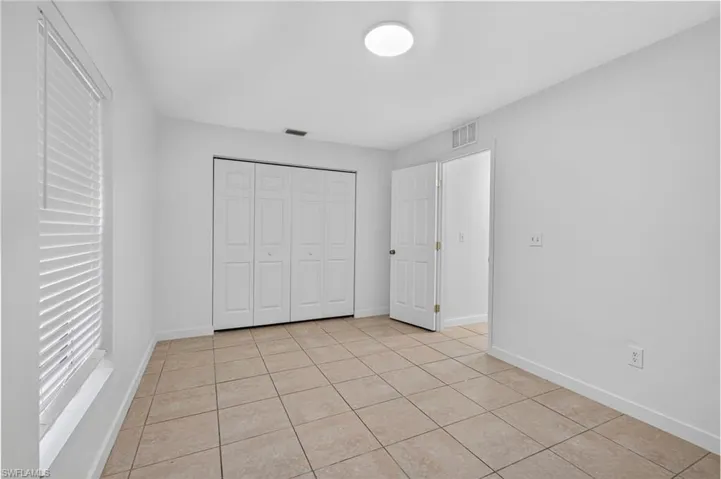 Unfurnished bedroom with light tile patterned floors and a closet