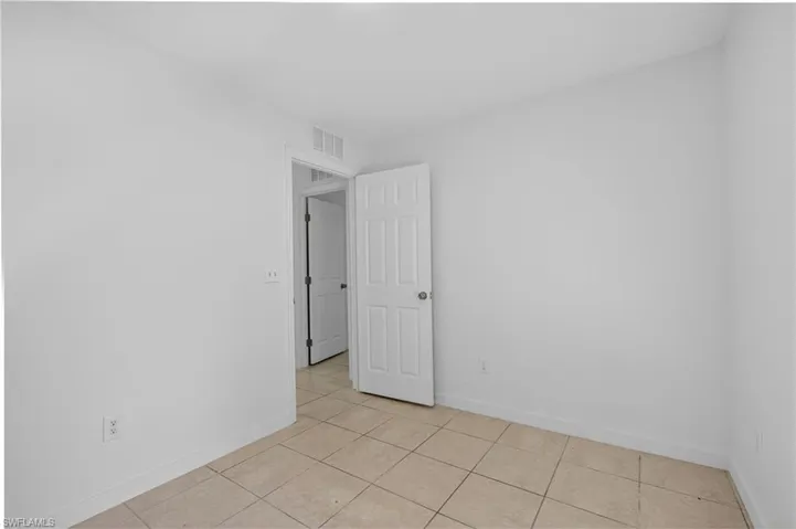 Spare room featuring baseboards and light tile patterned flooring